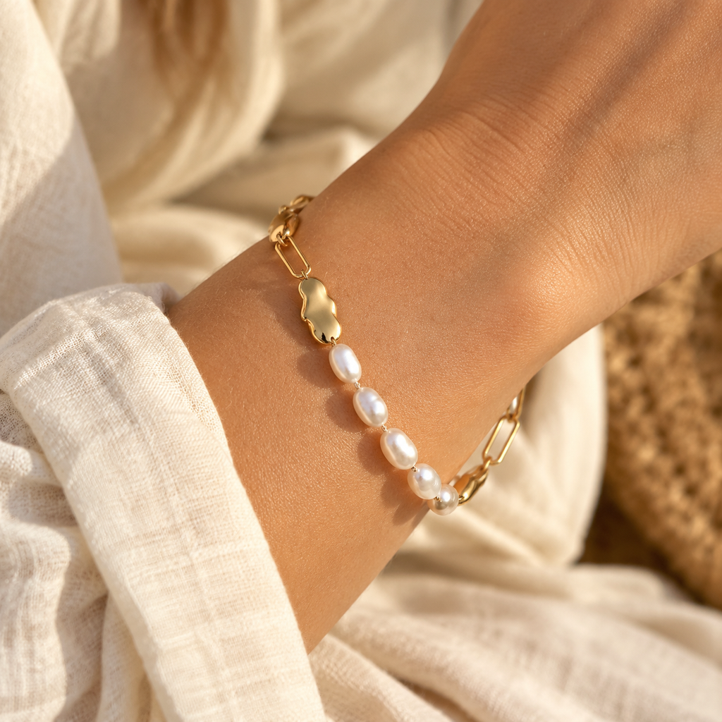 Lifestyle photo of woman wearing asymmetrical freshwater pearl link bracelet with cream linen shirt
