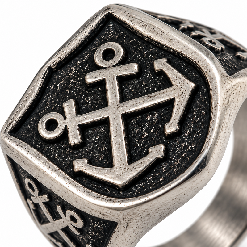 Macro close-up of sculpted maritime anchor emblem on shield signet face
