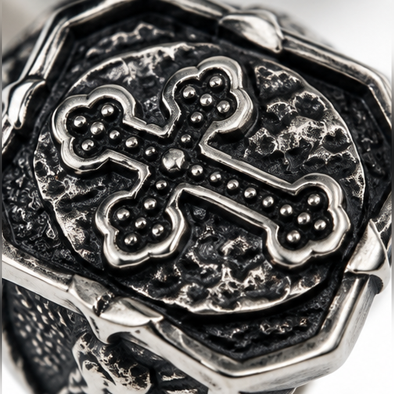 Close up of detailed beaded gothic trefoil cross on blackened shield

