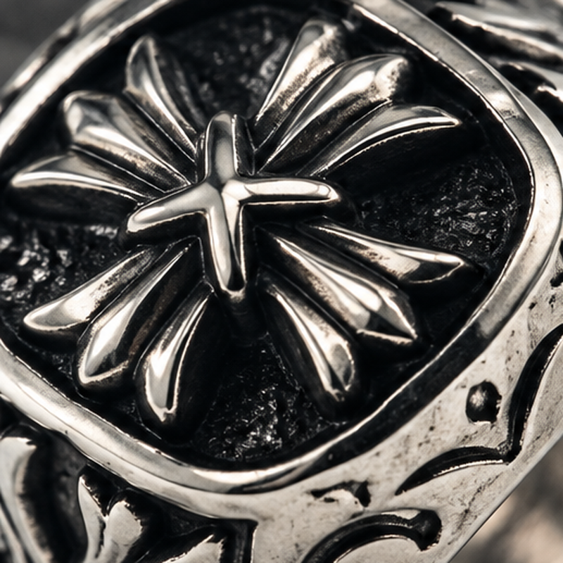 Macro close-up of three-dimensional sculpted fleur cross emblem on square signet face