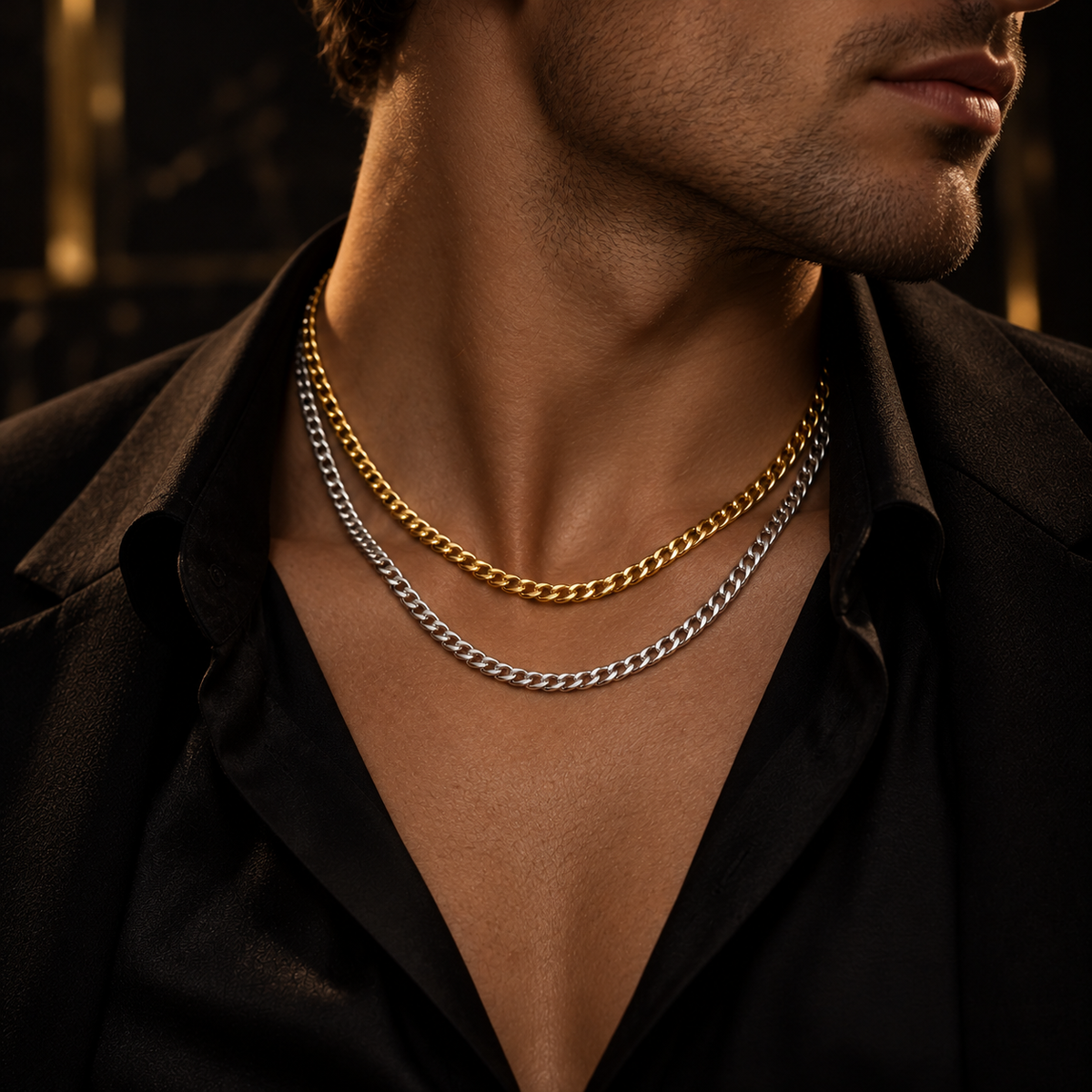 Model wearing layered gold and silver Cuban link chain necklaces with black suit
