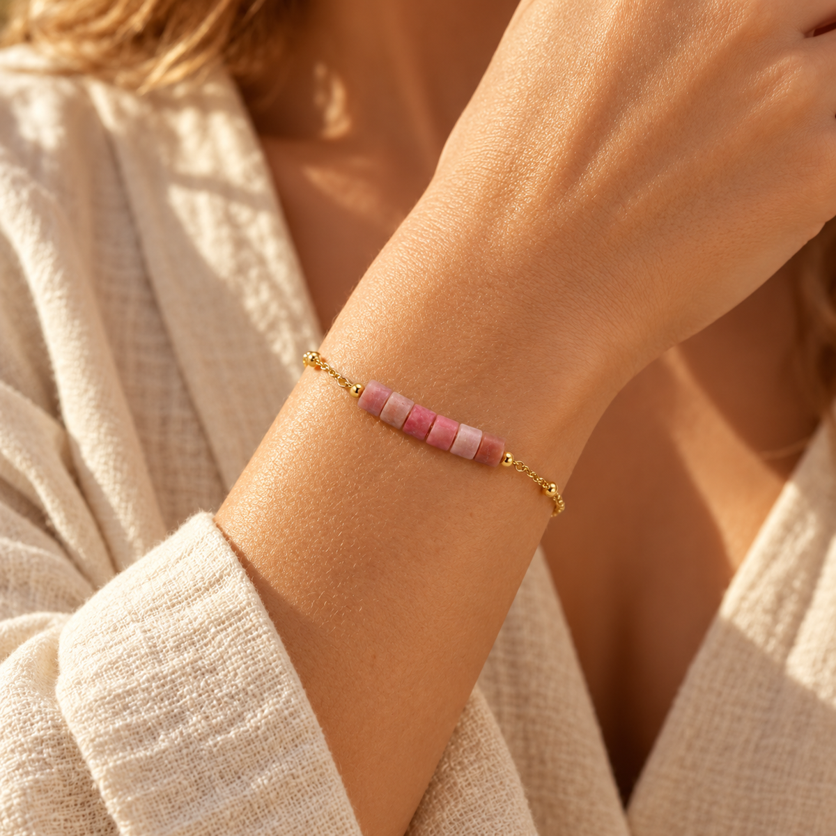Close-up of a woman's wrist wearing the minimalist pink stone tube bead bar chain bracelet in soft natural light.
