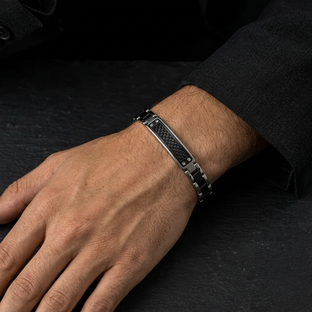 Close-up wrist view of men's two-tone carbon grid bracelet on black marble counter
