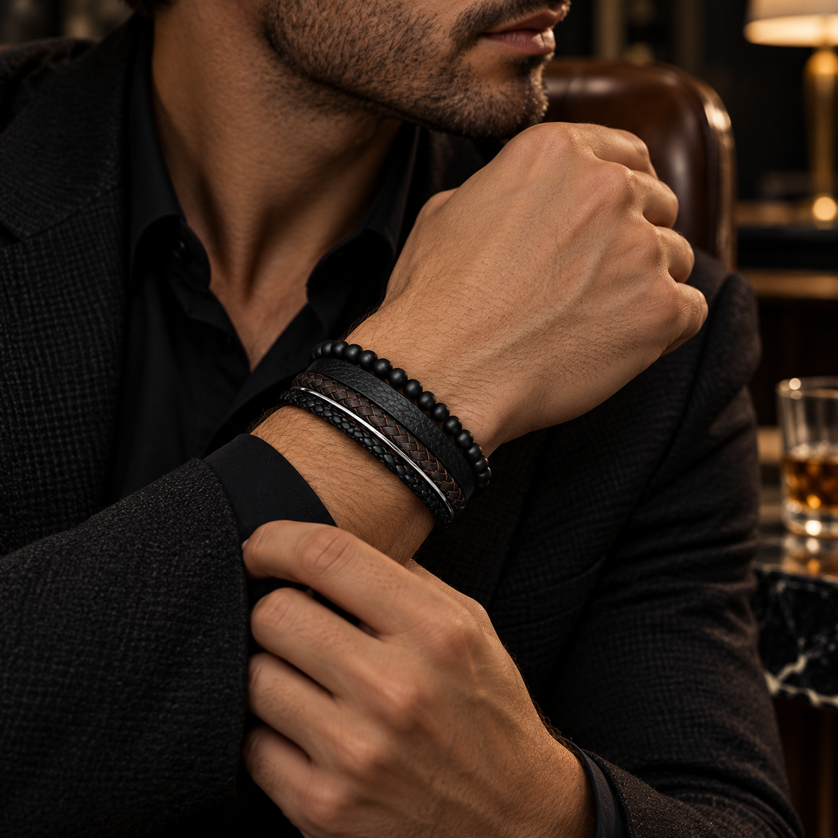 Male wrist wearing matte black onyx beaded leather bracelet with tailored blazer
