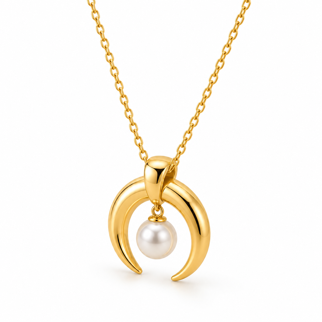 Detailed macro view of polished gold crescent double horn charm holding lustrous round pearl drop

