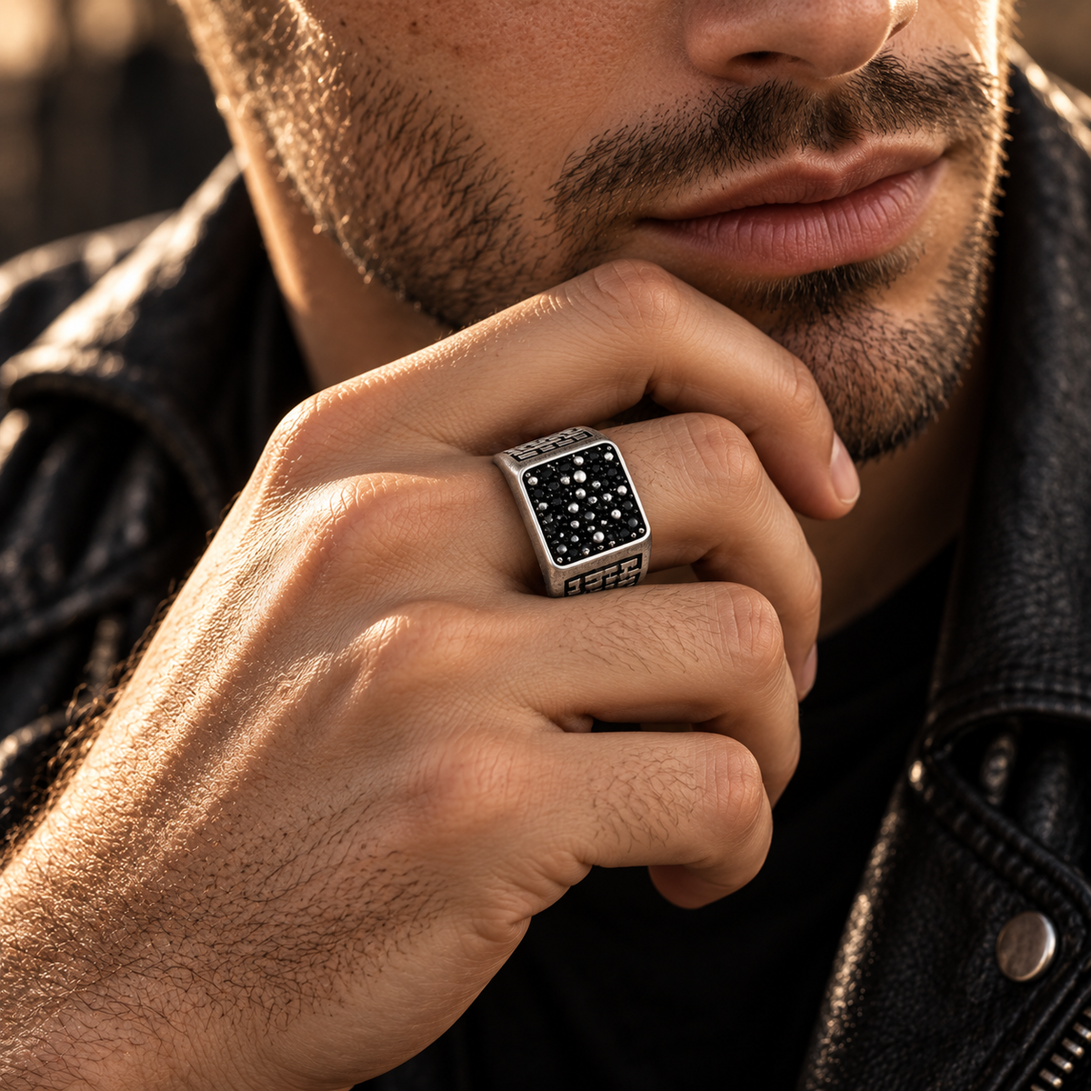 Close up of pave black stones and silver spheres on signet ring face
