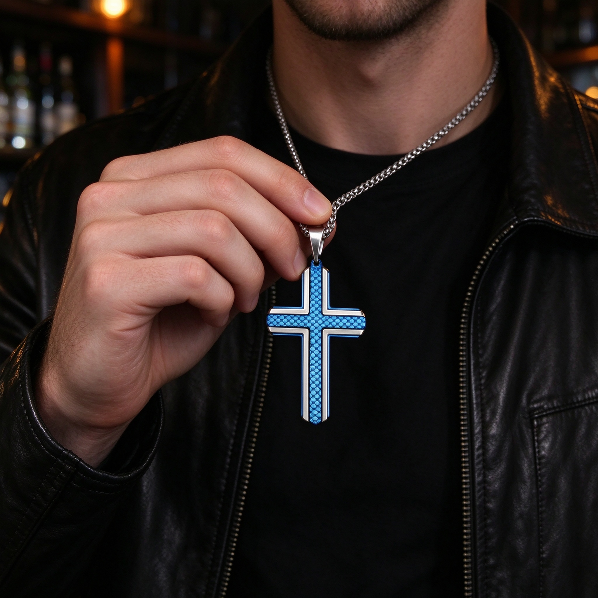 Model holding men's royal blue carbon fiber cross pendant necklace with black jacket

