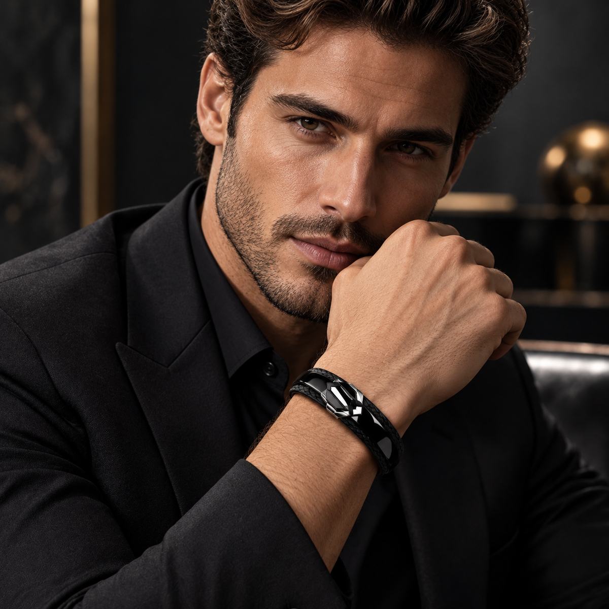 Portrait of handsome male model in black tailored suit wearing Men's geometric crest bracelet
