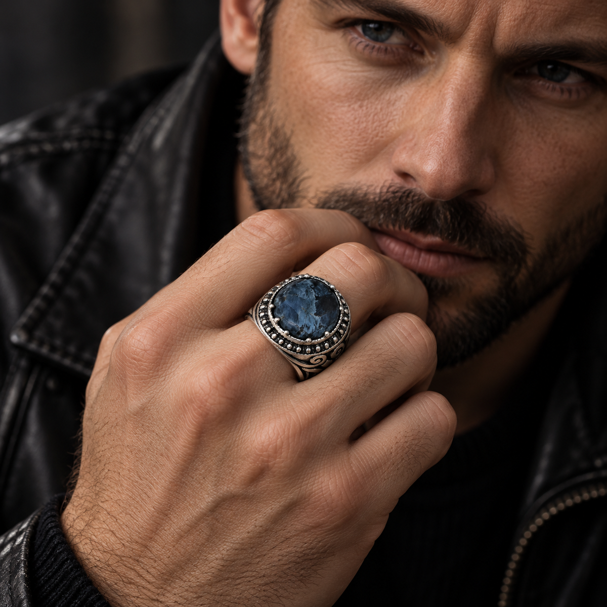 Close-up of bearded male model in leather jacket wearing stainless steel sodalite ring
