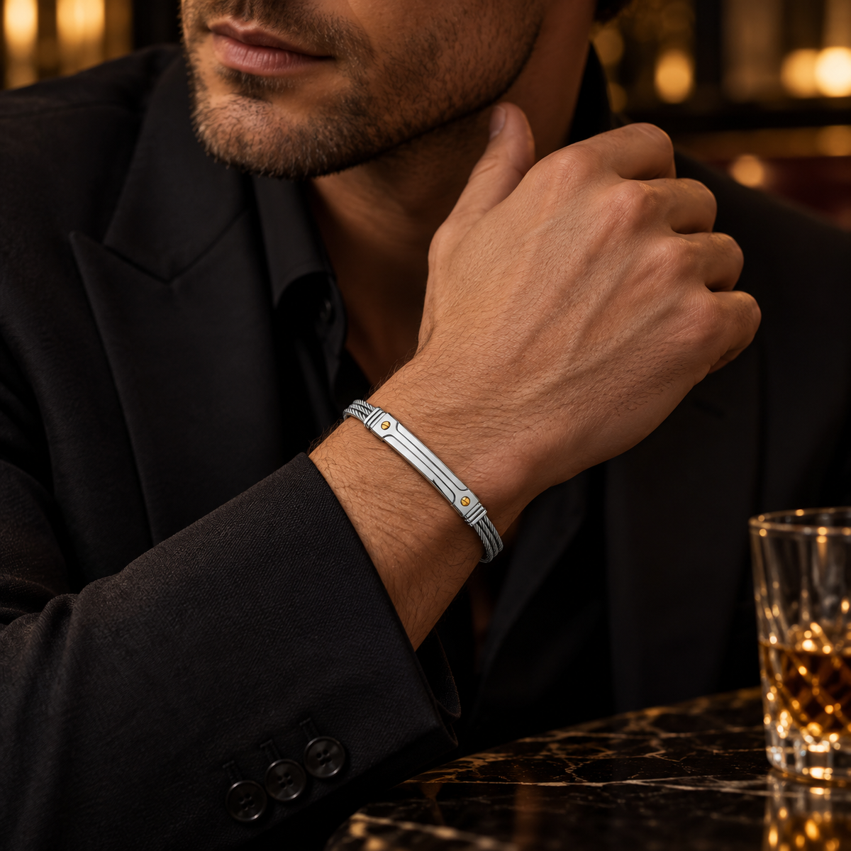 Model wearing men's stainless steel screw accent wire cable bracelet with formal black suit
