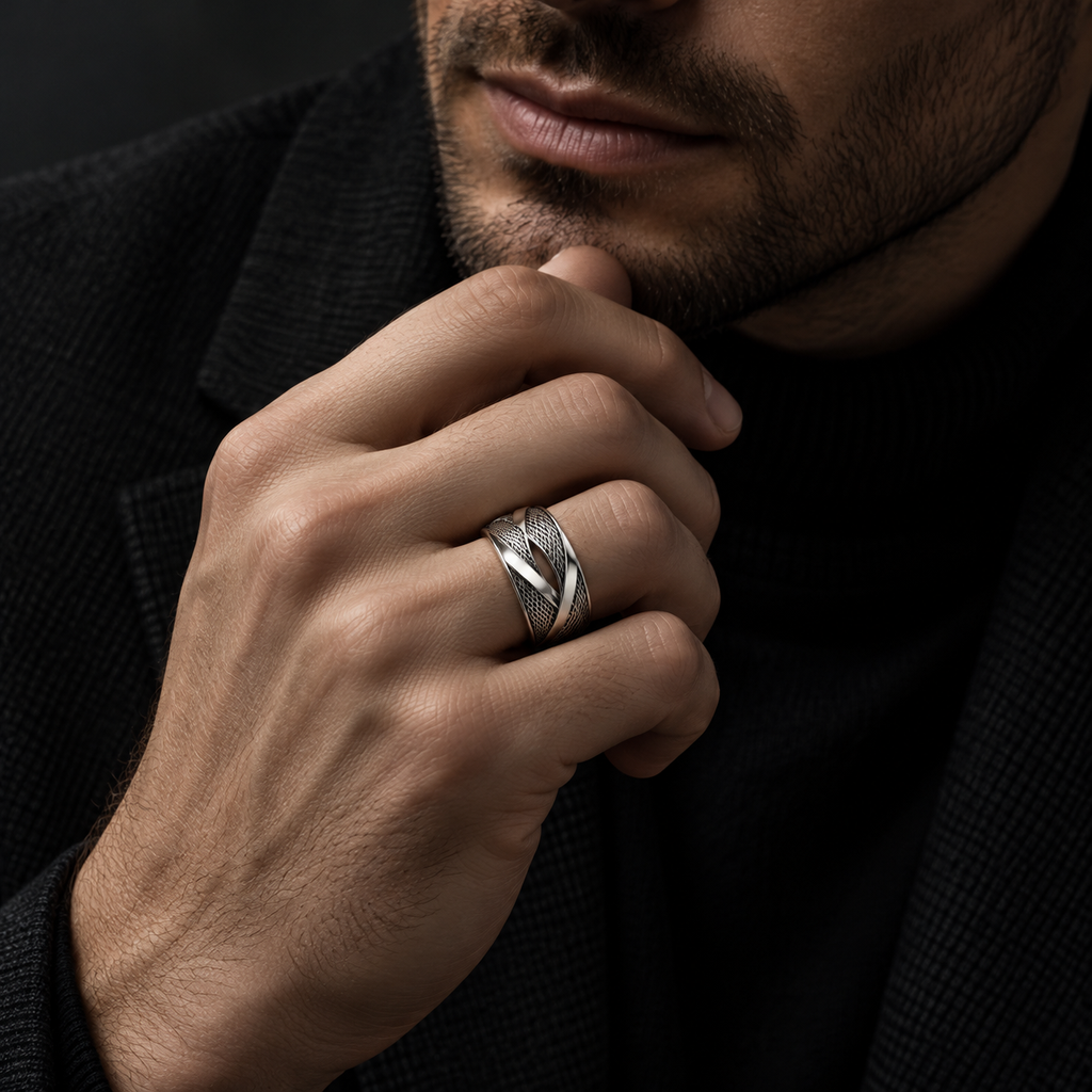 Male hand touching chin wearing stainless steel cyber mesh ring with black coat
