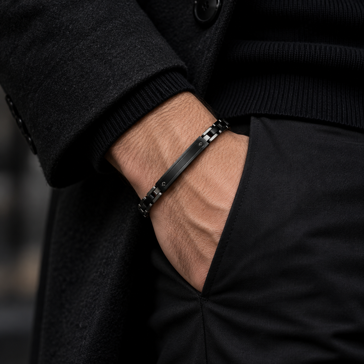 Model wearing men's all-black motorcycle chain bracelet with hand in pocket
