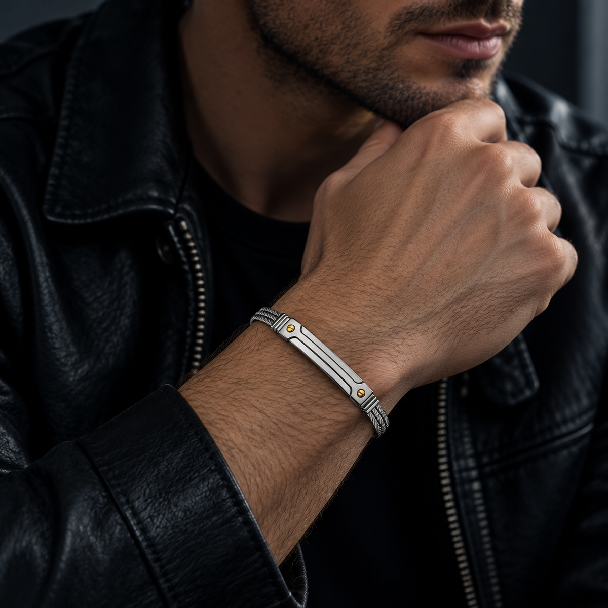 Model wearing men's steel cable gold screw rivet ID bracelet with black leather jacket
