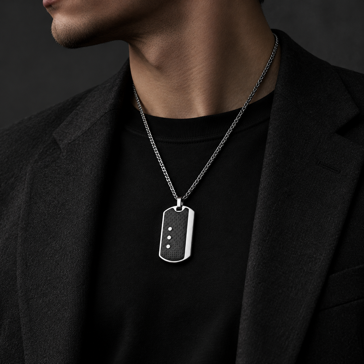 Model wearing men's industrial carbon fiber tag necklace with tailored black blazer

