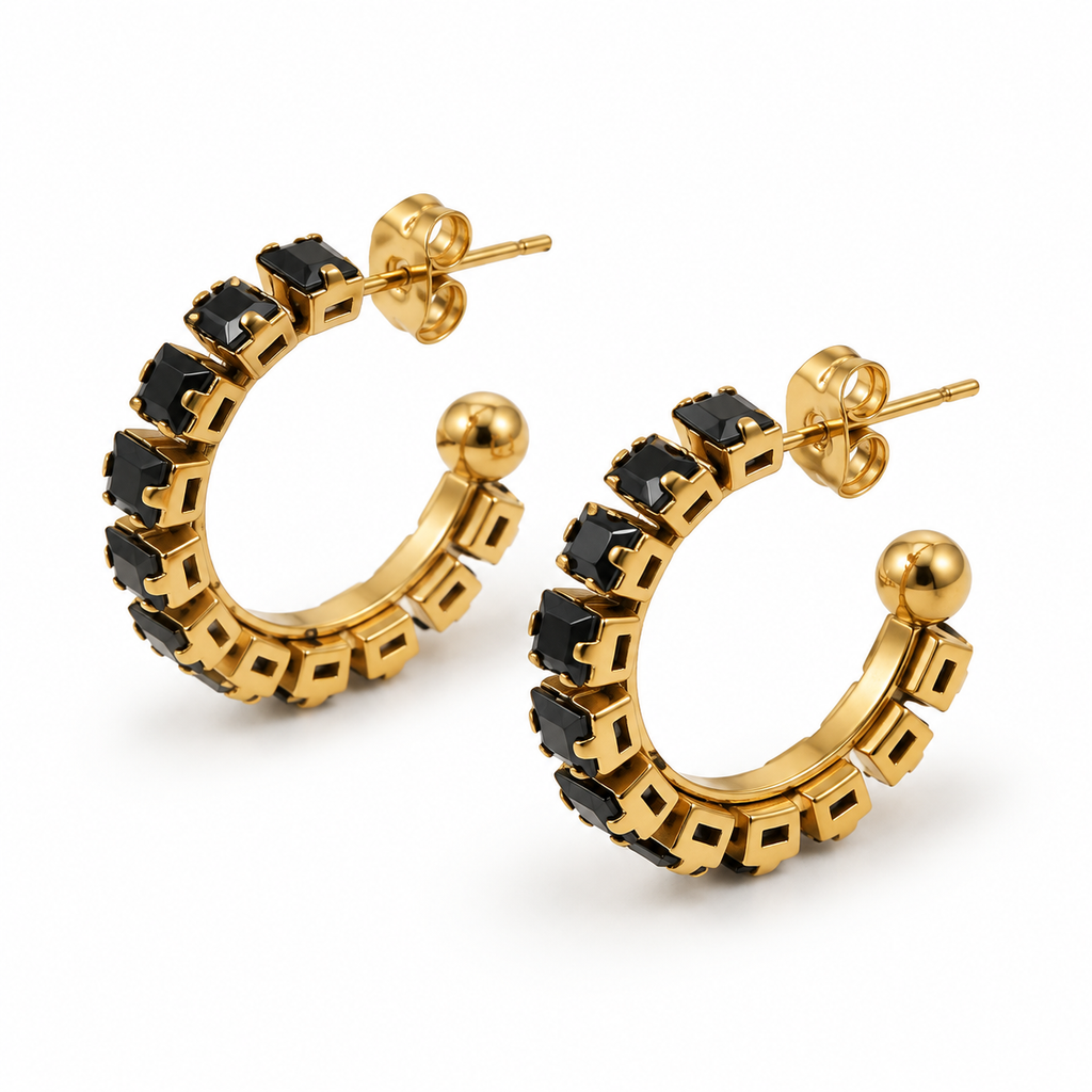 Pair of women's chunky gold open C-hoop earrings set with faceted square black zircon stones on white background
