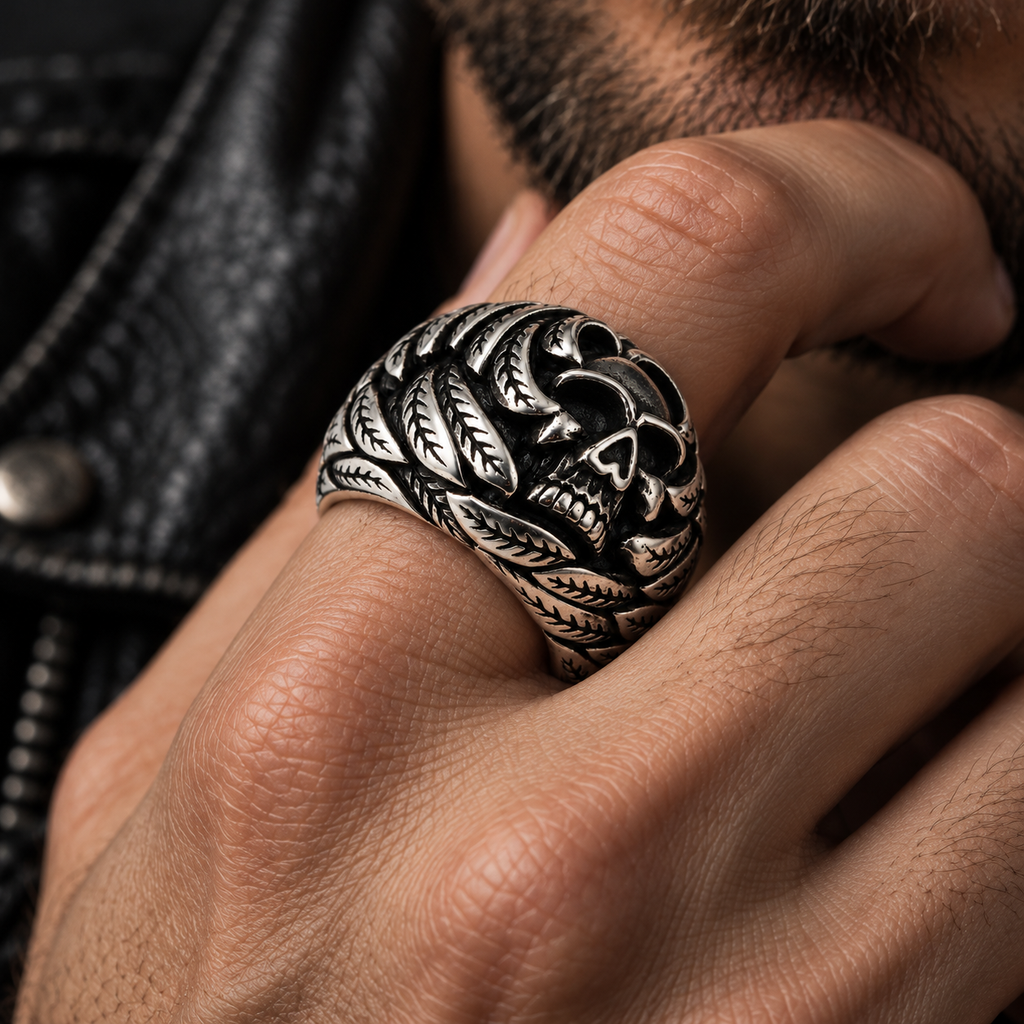 Close up of textured leaf veins and grinning skull face on biker ring
