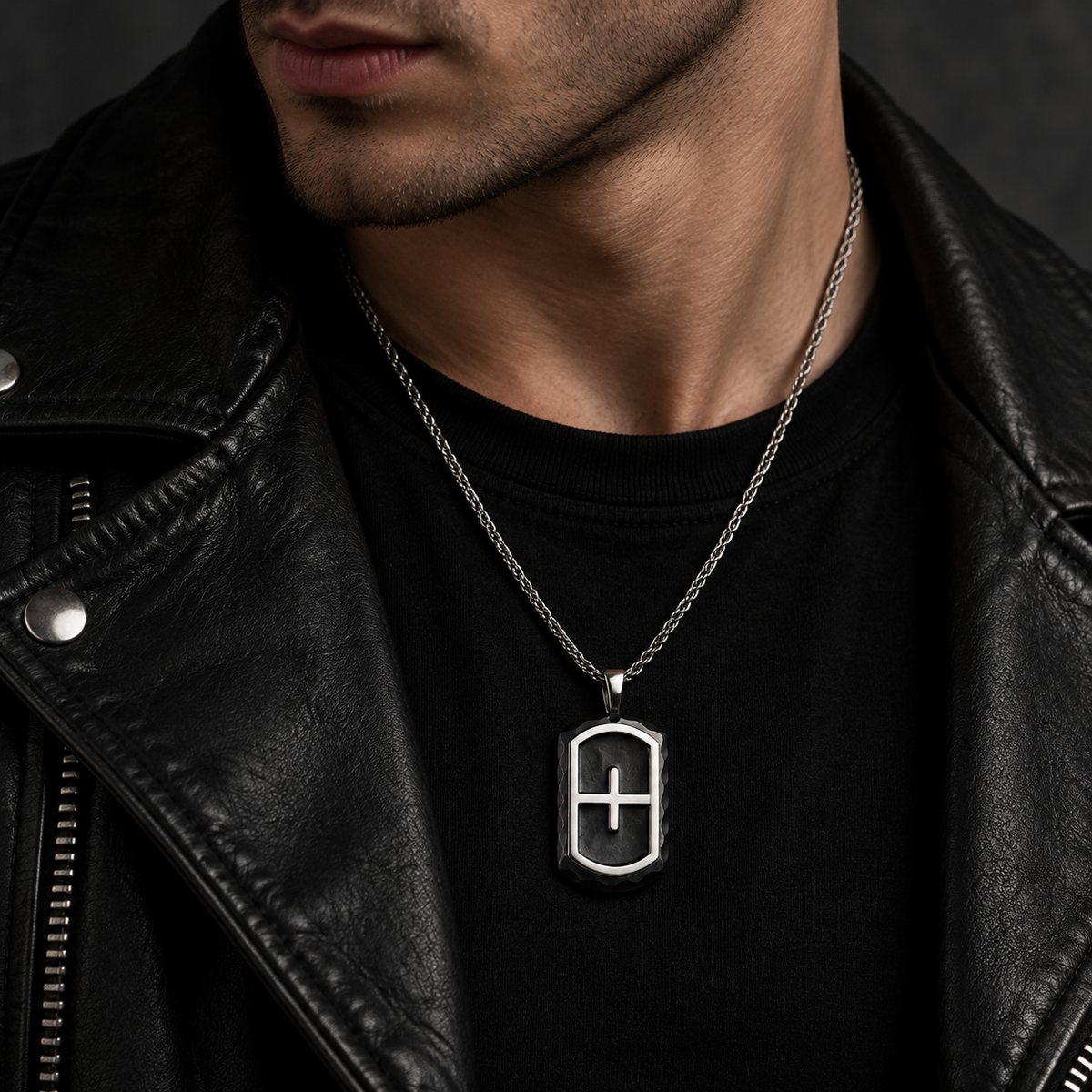 Model wearing men's black chiseled cross shield dog tag necklace with leather biker jacket
