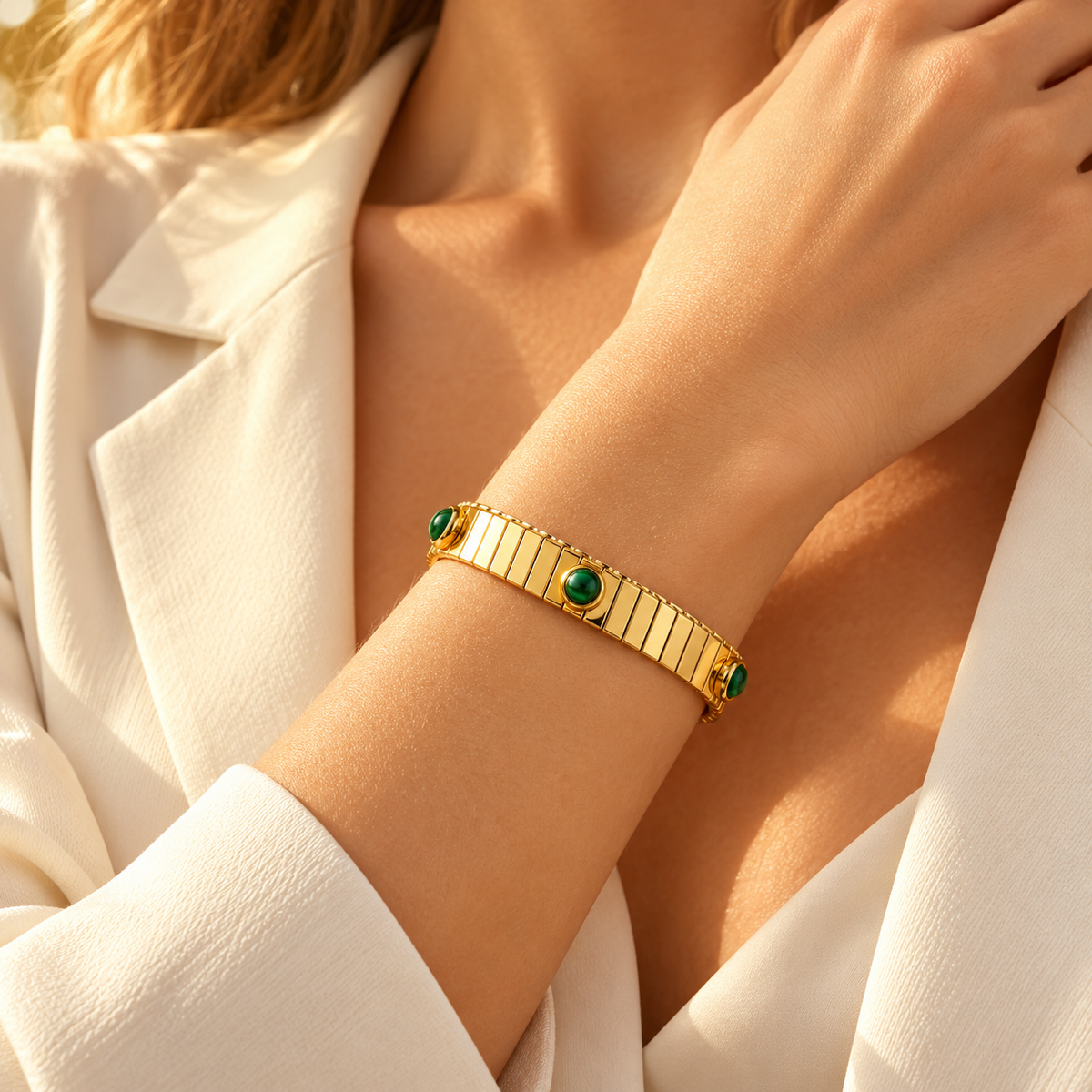Model resting hand on chest showcasing vintage Italian style expandable gold bracelet adorned with green cabochons
