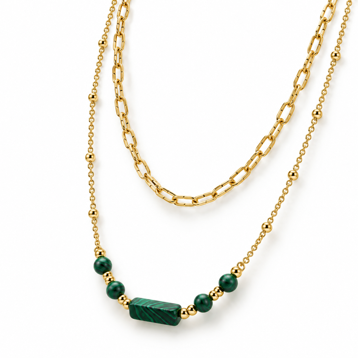 Detailed product flat lay of the layered gold chain necklace highlighting the engraved green malachite cylinder bar and bead accents.
