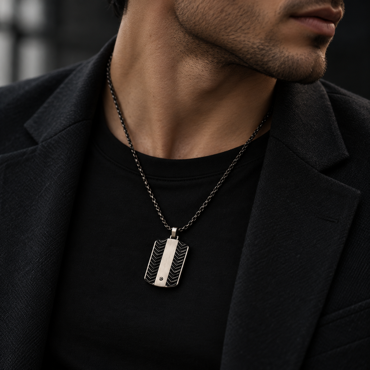 Model wearing men's chevron dog tag pendant necklace with formal black suit
