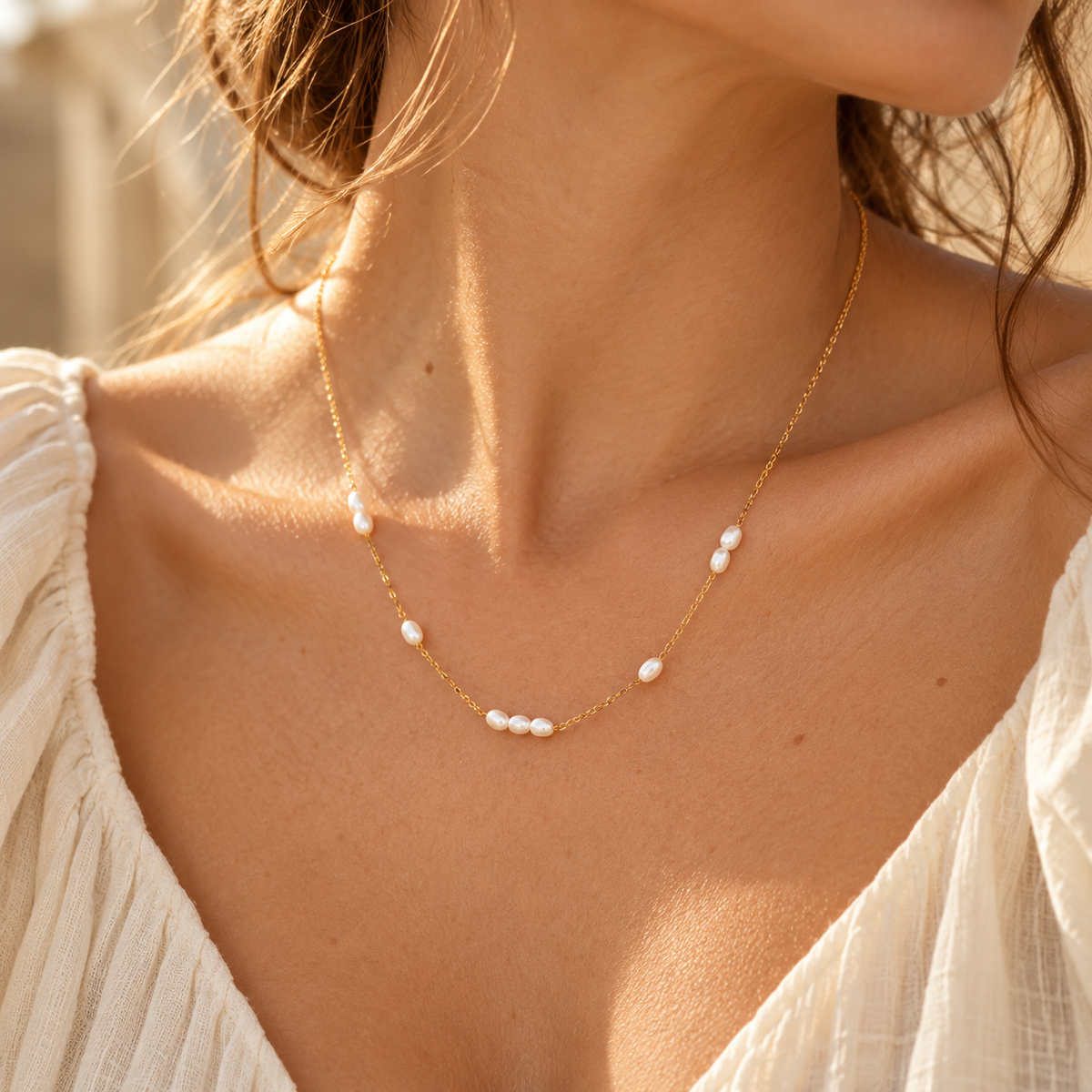 Detail view of women's gold pearl choker necklace accentuating the collarbone

