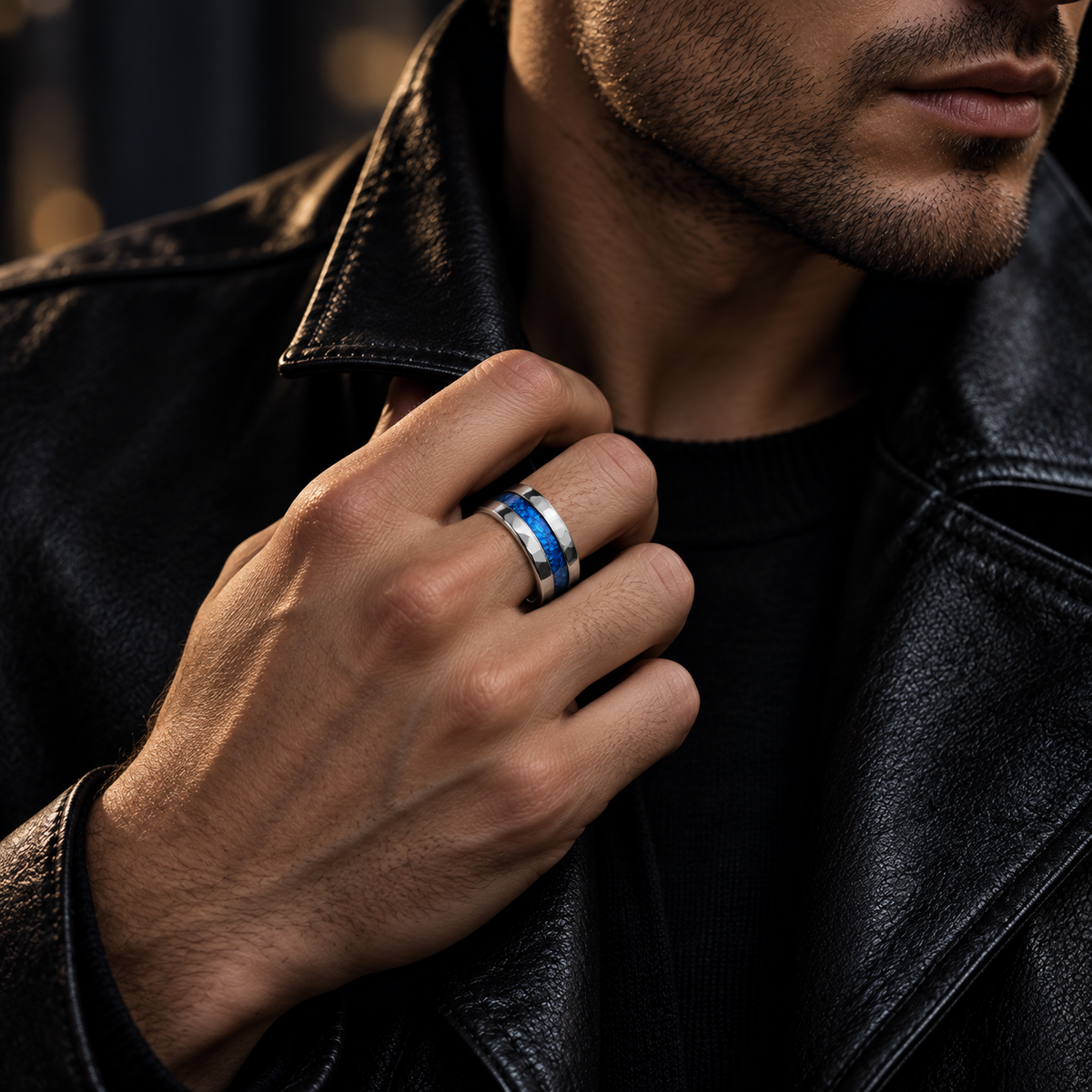 Lifestyle close-up of male hand touching jacket collar wearing blue opal stainless steel ring
