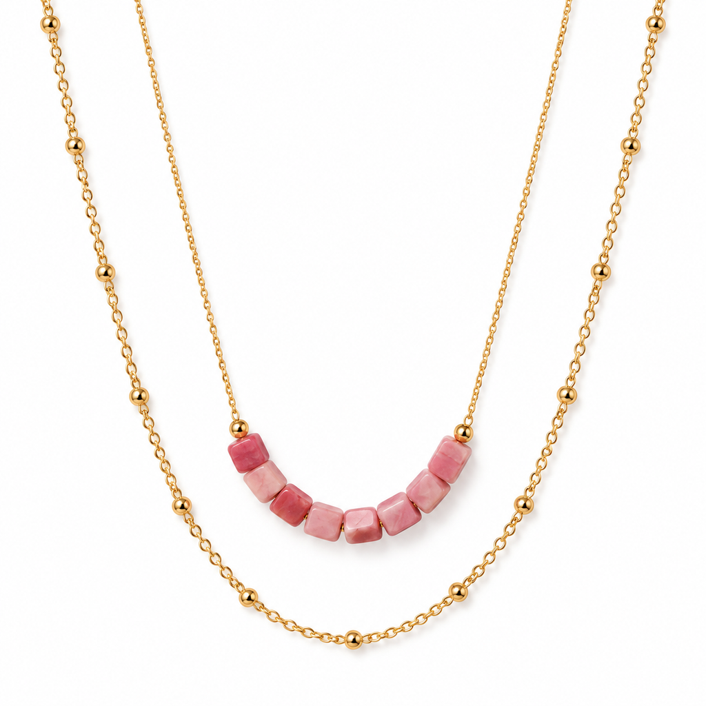 Women's layered gold necklace featuring natural pink rhodonite cube beads and a dainty beaded satellite chain.
