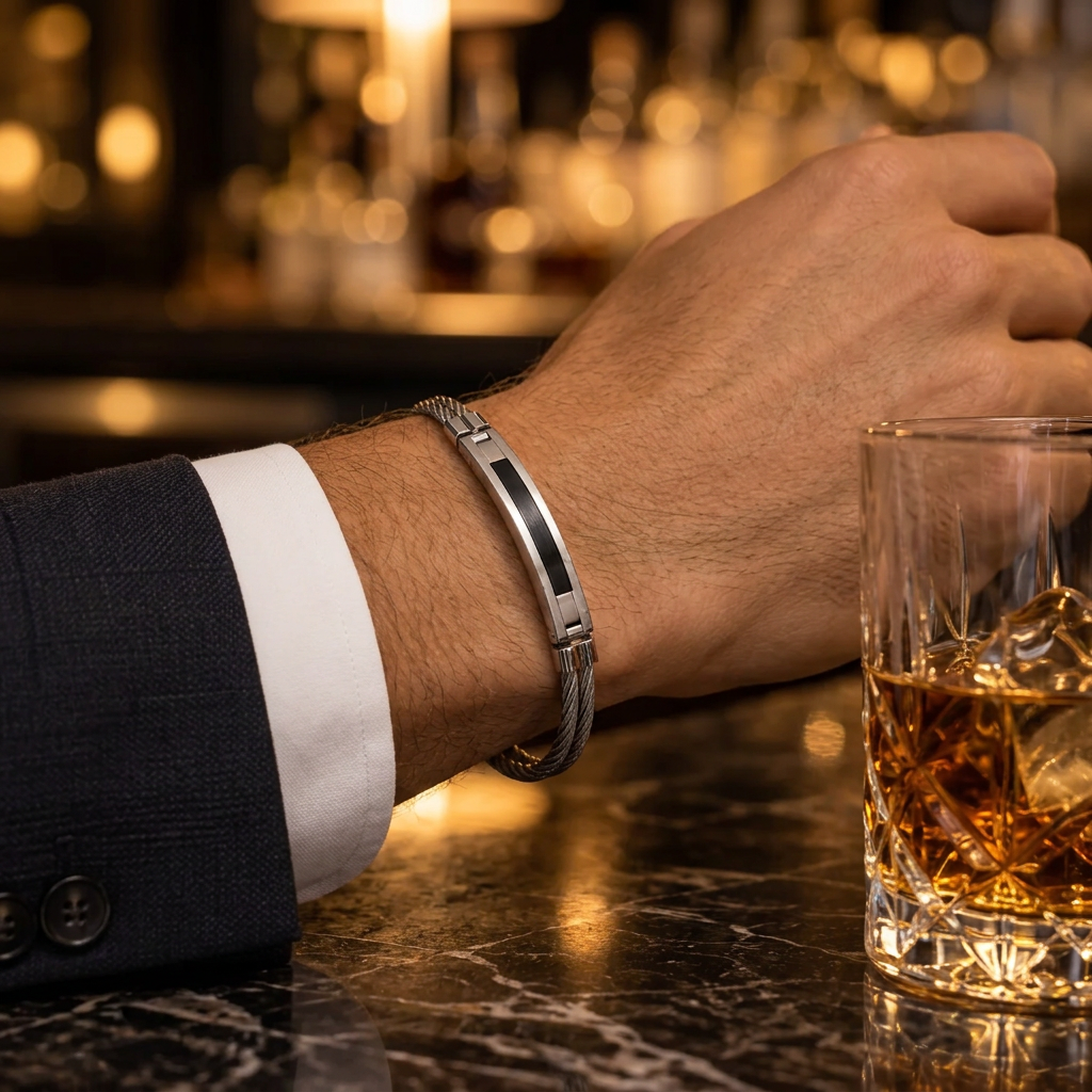 Close-up wrist view of men's twisted cable black inlay bracelet on marble bar table
