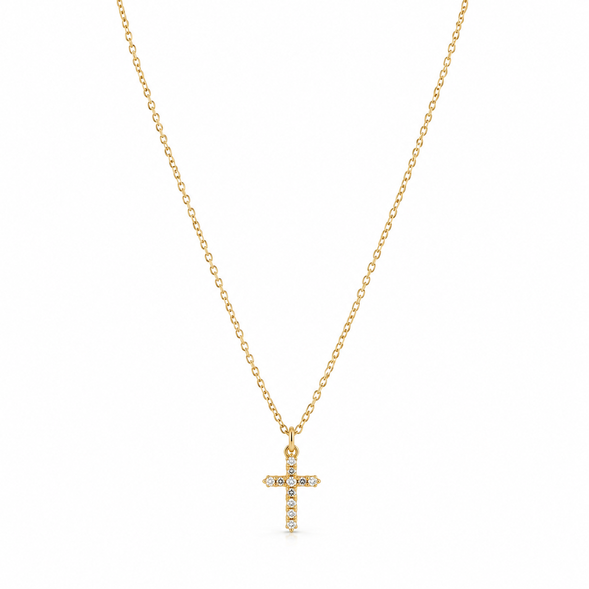 Dainty gold cable chain necklace with micro CZ crystal cross charm against white background
