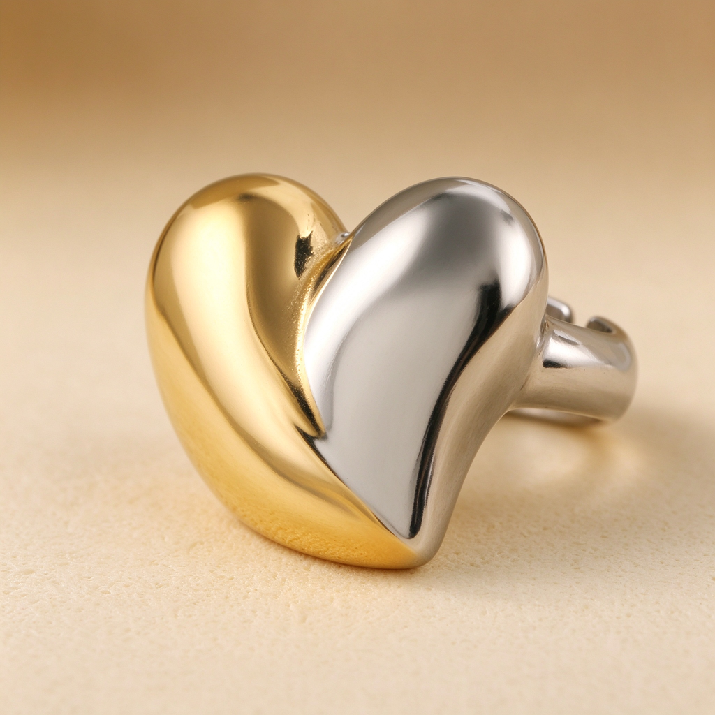 Macro studio shot of two-tone gold and silver puffy heart ring showing open adjustable band
