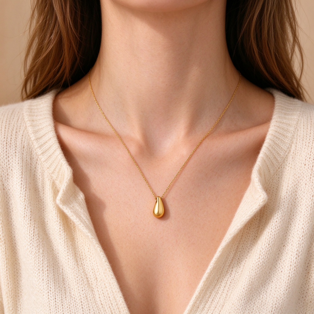 Model wearing women's gold waterdrop pendant necklace with delicate chain
