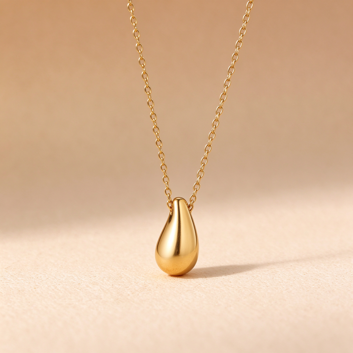 Close up view of polished gold water drop pendant necklace tarnish free jewelry
