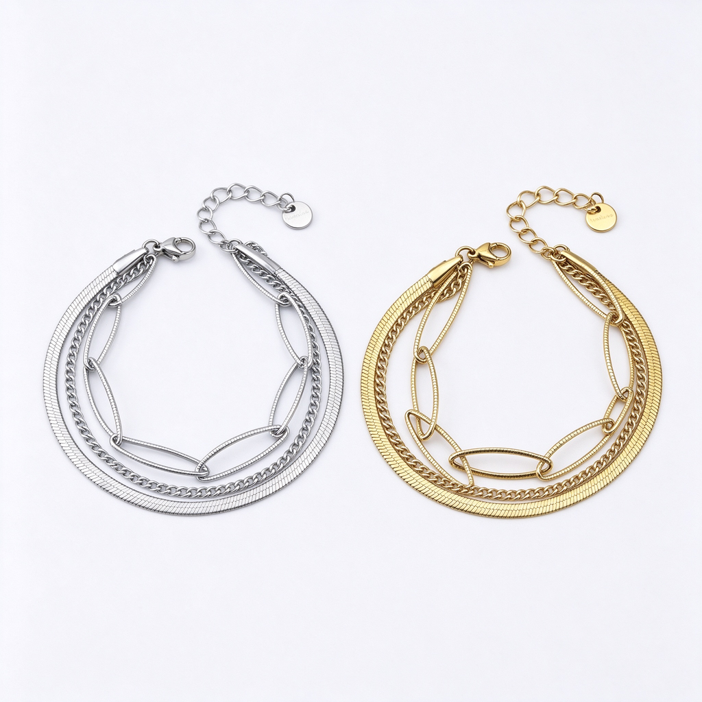 Women's triple layer chain bracelet with herringbone, curb, and paperclip links in gold and silver on white background
