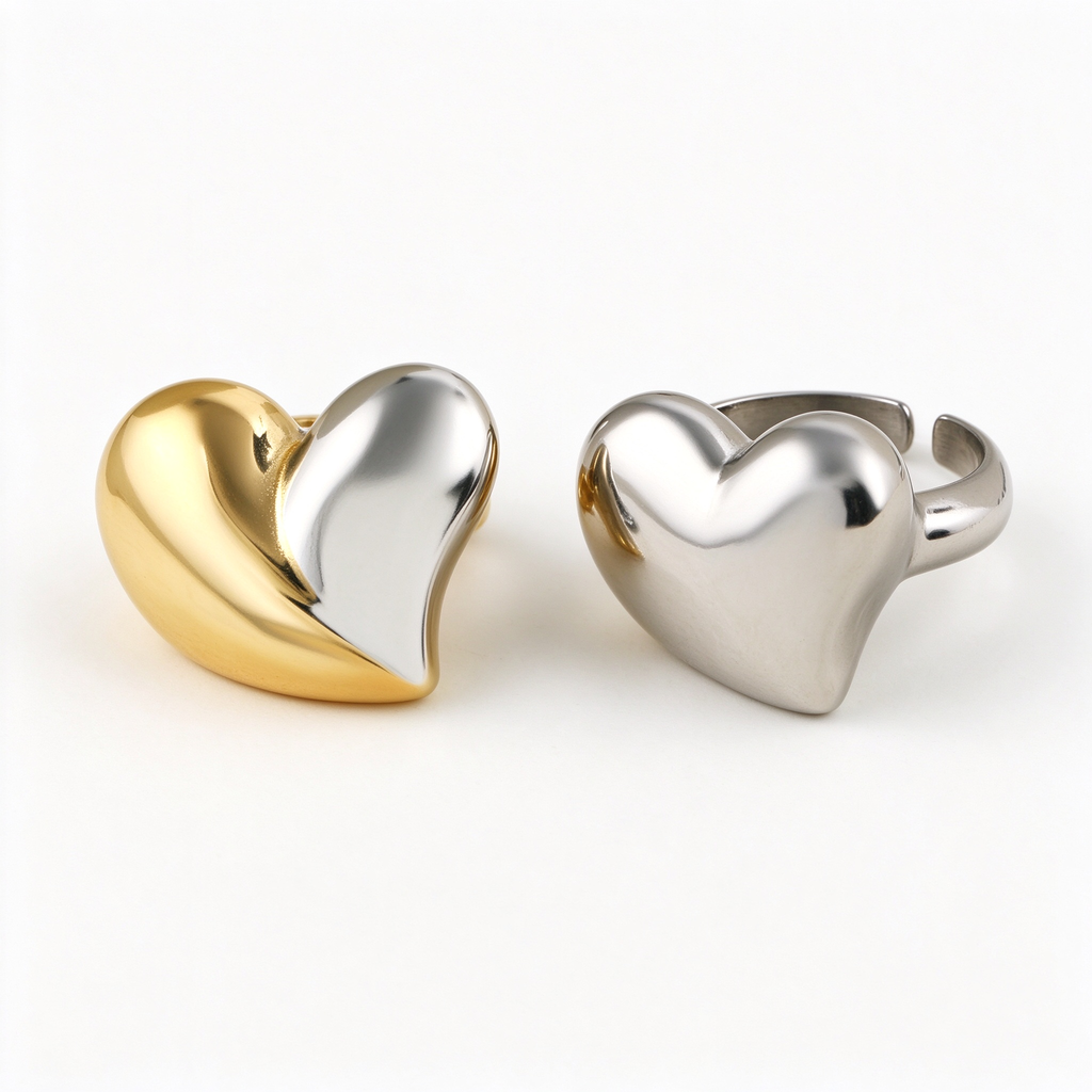 Two-tone gold and silver split puffy heart ring and solid silver chunky dome ring on white background
