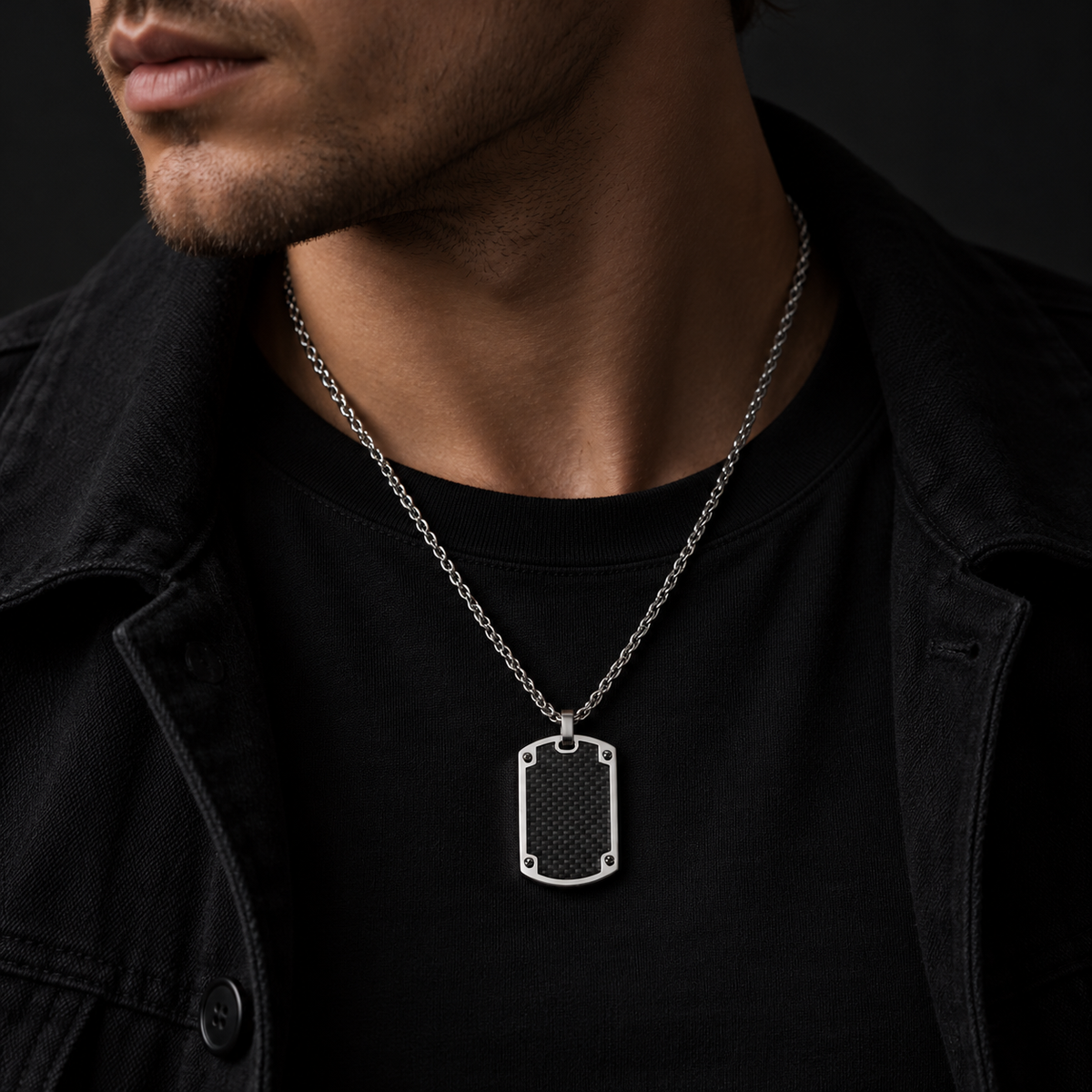 Model wearing men's carbon fiber dog tag pendant necklace with black denim jacket

