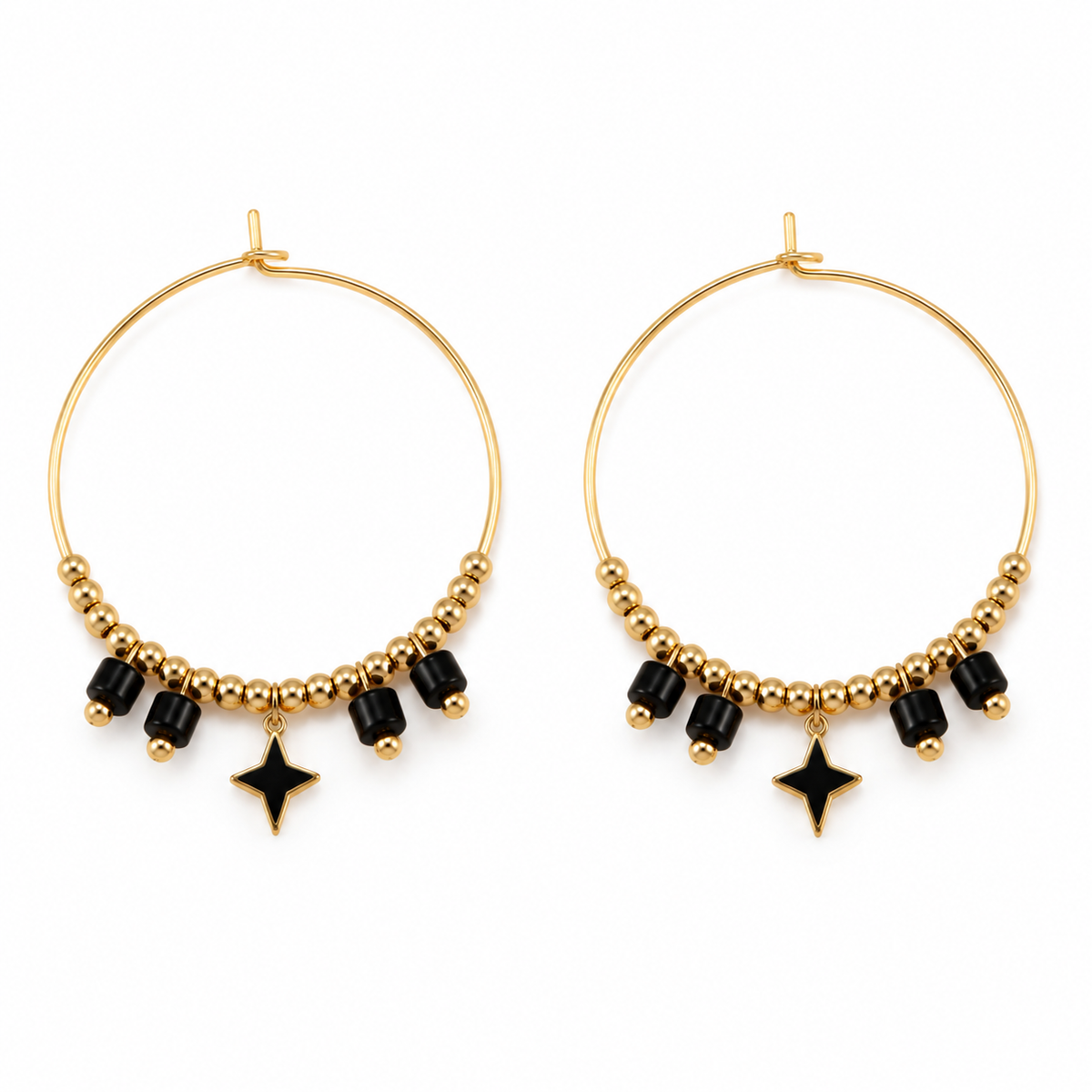 Pair of women's boho gold hoop earrings with black cylinder beads and dangling four-point black star charms on white background
