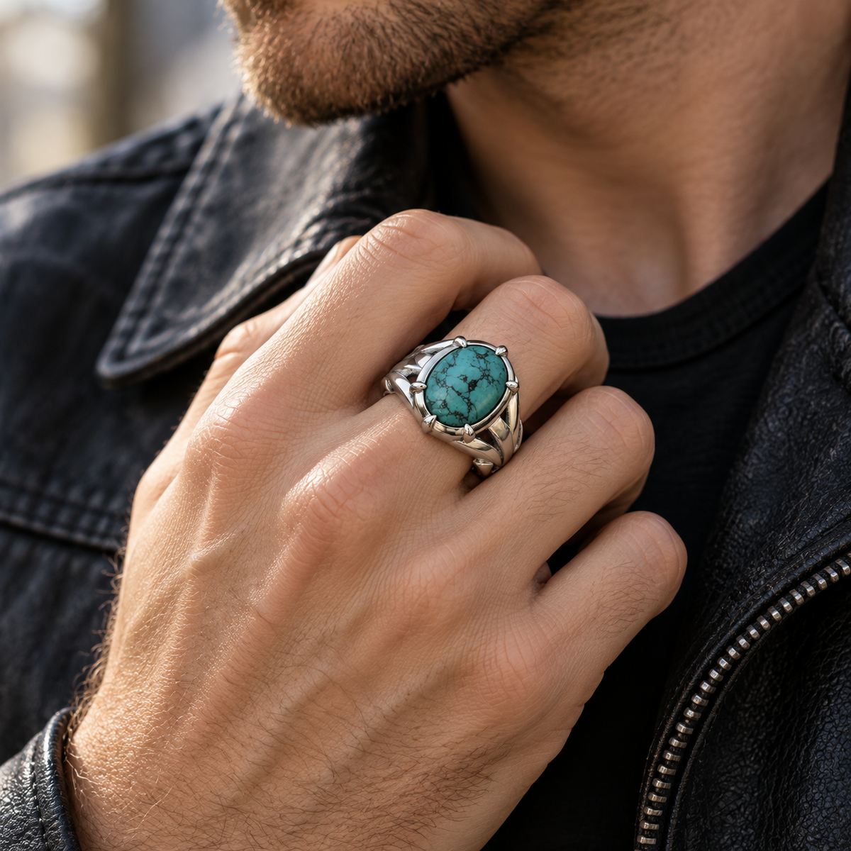 Male hand wearing stainless steel turquoise ring paired with black leather jacket
