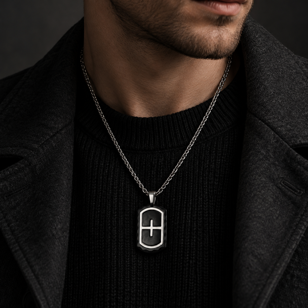 Model wearing men's two-tone steel cross shield dog tag on dark ribbed knit sweater
