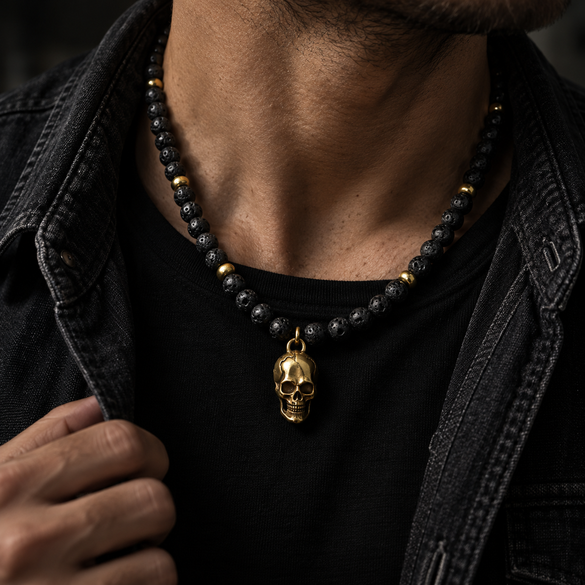 Model holding jacket lapel wearing men's vintage skull lava rock necklace
