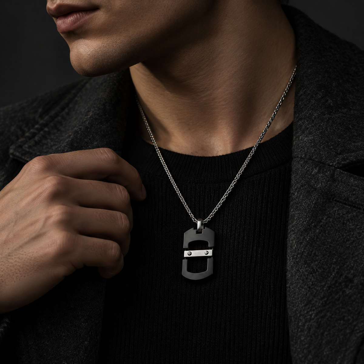 Model wearing men's futuristic geometric tag pendant necklace on dark crewneck sweater

