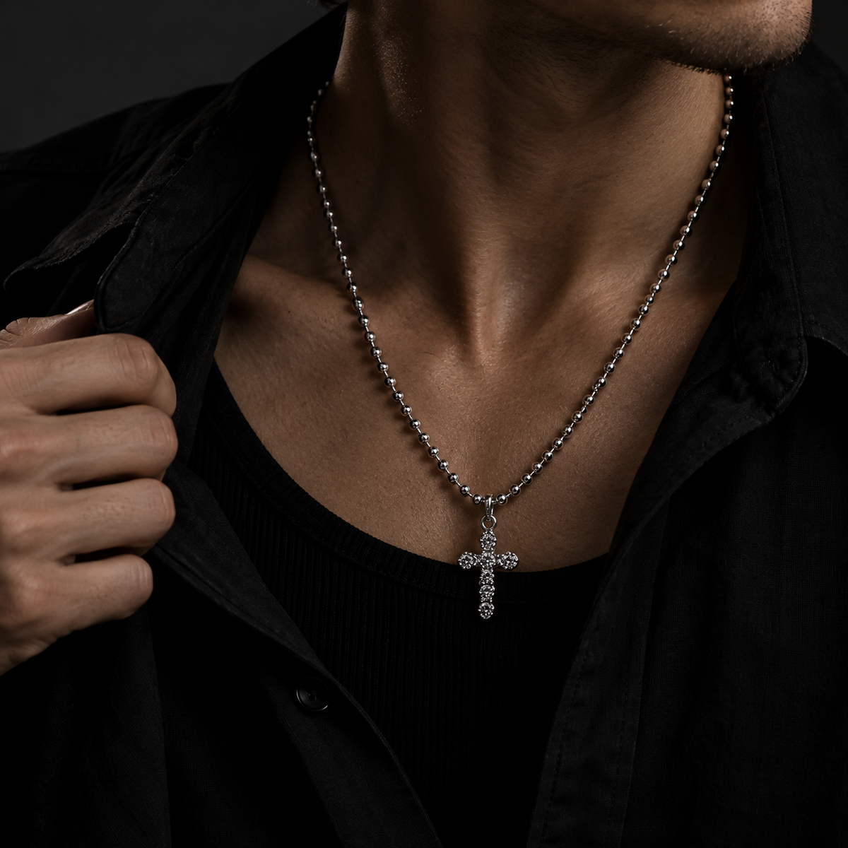 Model wearing men's sparkling cubic zirconia cross necklace with unbuttoned black shirt
