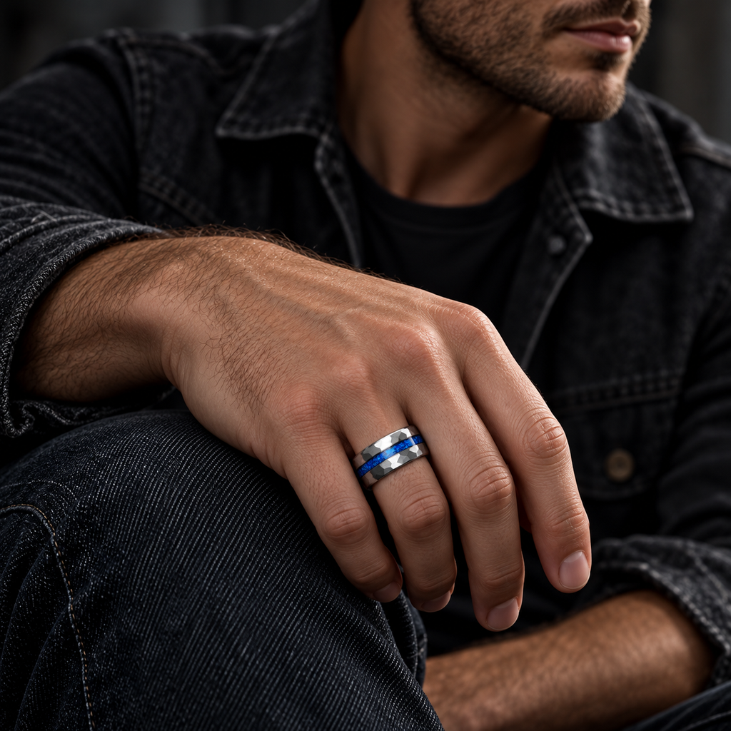 Male hand resting on knee wearing Men's faceted blue opal wedding band with denim shirt
