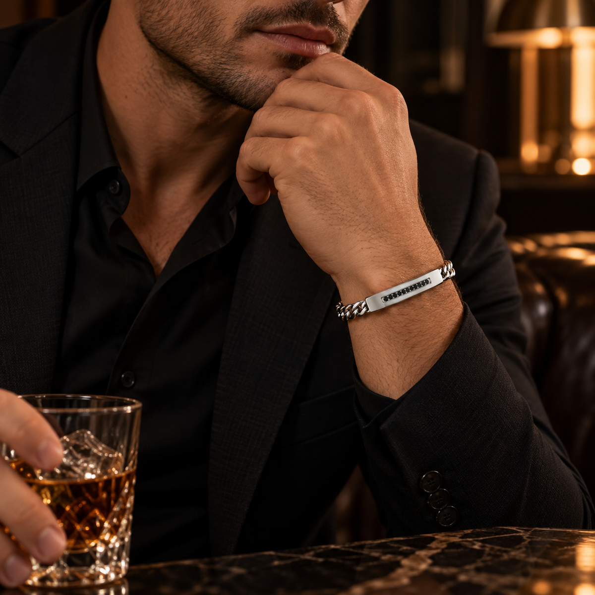 Model wearing men's stainless steel ID bracelet with tailored black suit

