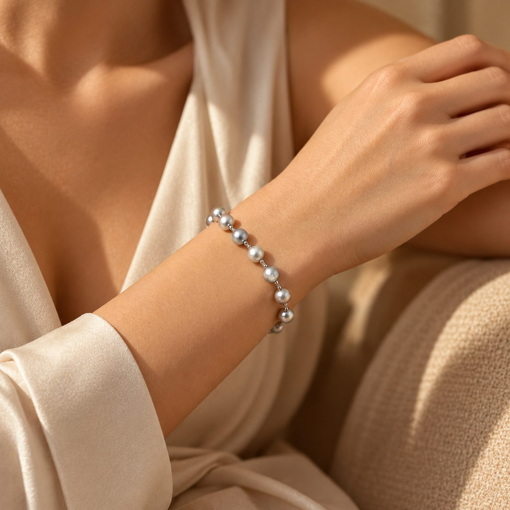 Woman wearing silver and charcoal grey pearl bead bracelet with elegant white dress
