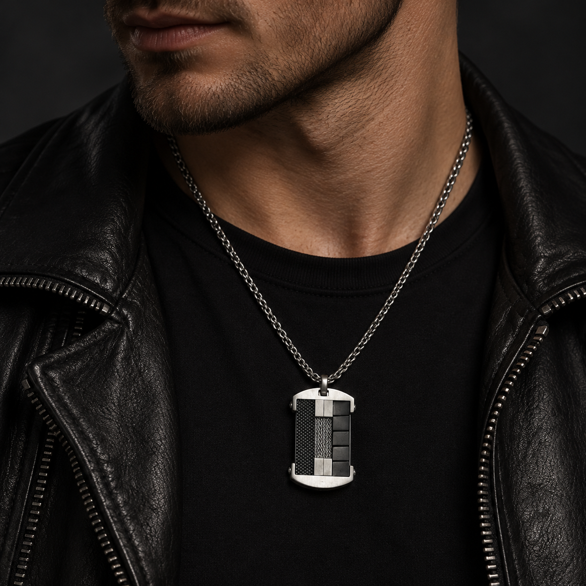 Model wearing men's carbon fiber and cable tag pendant necklace with black leather jacket
