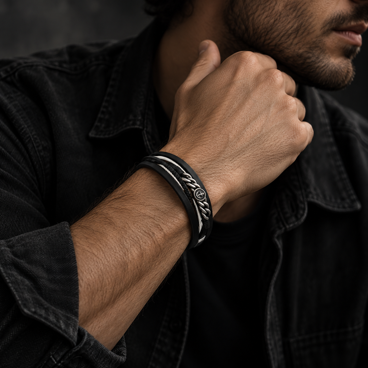 Male model in black denim shirt touching neck showing Men's braided eagle chain bracelet
