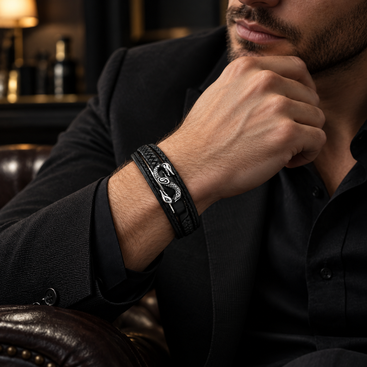 Gentleman in black blazer touching chin wearing Men's infinity serpent leather cuff
