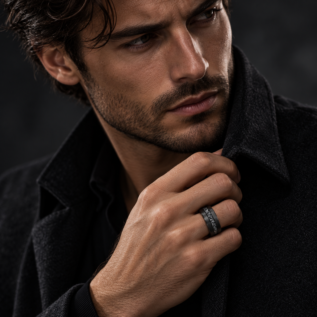 Male model in black overcoat adjusting lapel while wearing black stainless steel band ring
