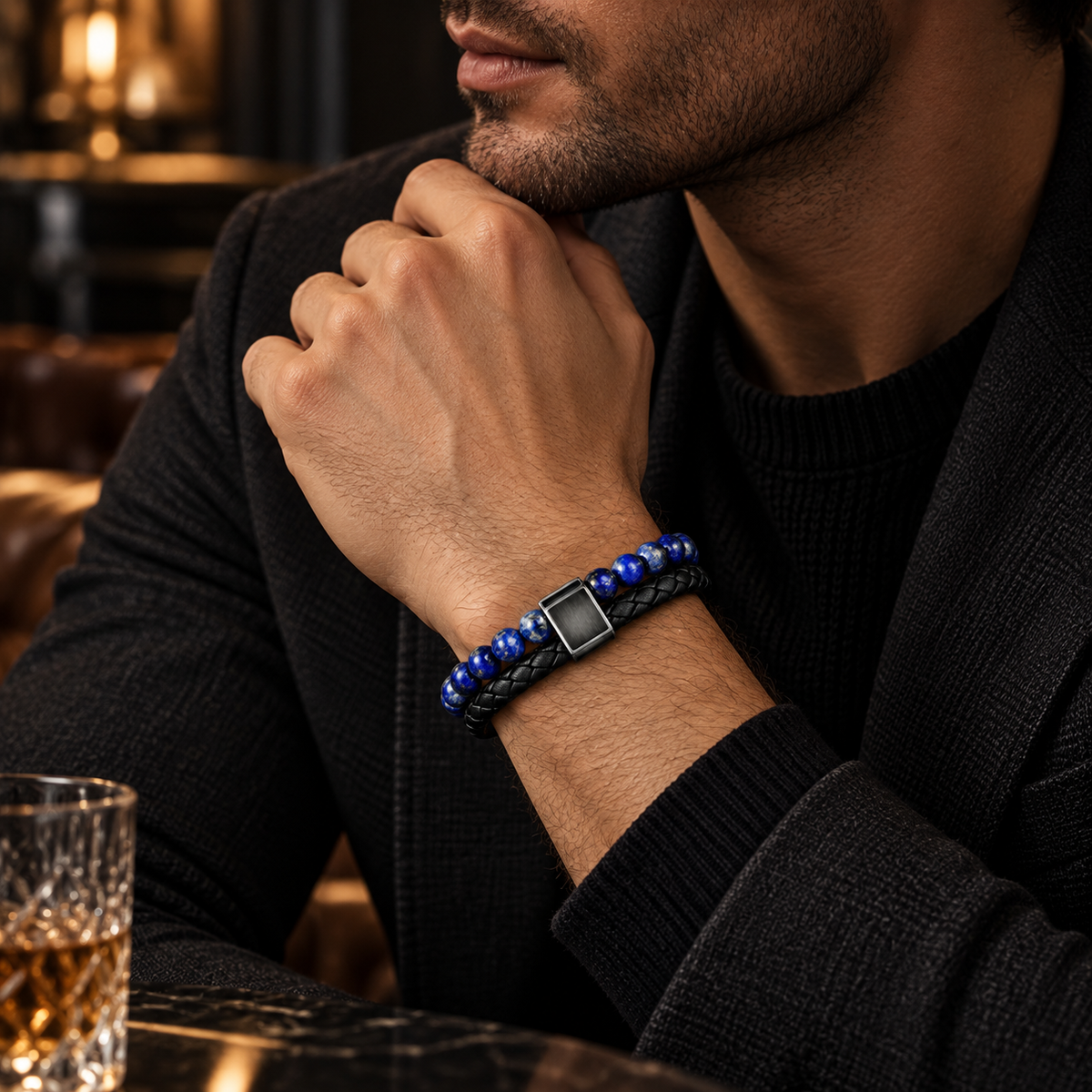 Gentleman at bar table touching beard showing blue lapis lazuli beaded braided bracelet
