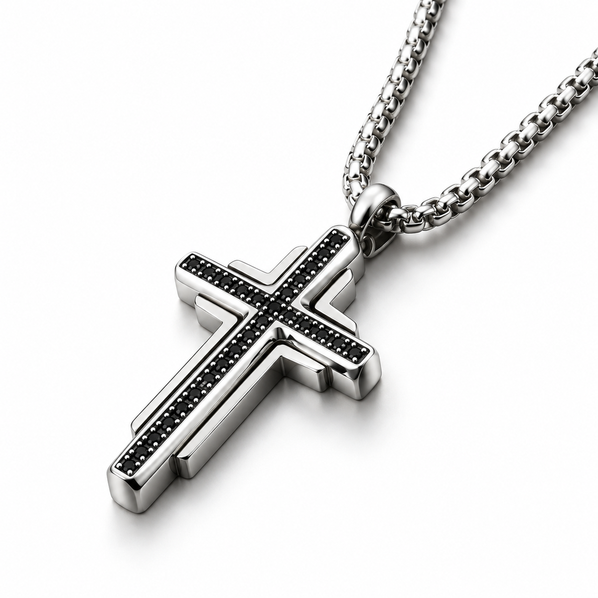 Macro studio angle of men's tiered black stone cross pendant on reflective white surface
